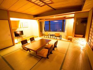 鸣门市凯格苏火影忍者日式旅馆的客厅配有木桌和椅子
