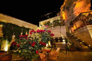 格雷梅罗马凯芙套房酒店的一个带红色玫瑰和桌椅的庭院