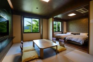 箱根箱根湖酒店的一间卧室配有两张床、一张桌子和一台电视。