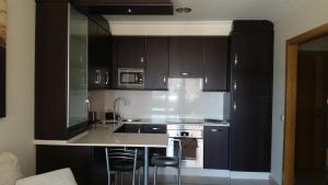 科巴罗Apartamento La Cantera的厨房配有深褐色橱柜和水槽