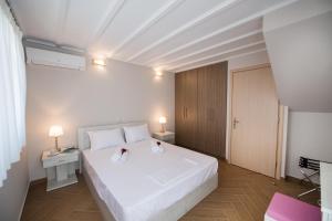 苏卡雷斯Lefkogea Villas & Apartments的卧室配有白色的床和2条毛巾