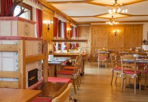 库马约尔Hotel Vallée Blanche Courmayeur的餐厅拥有木墙和桌椅