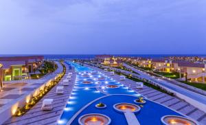 库塞尔Pickalbatros Sea World Resort - Marsa Alam- "Aqua Park"的夜间带船只的酒店游泳池