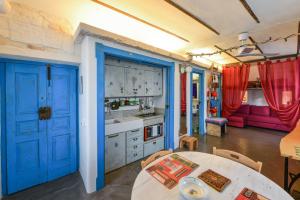马丁纳弗兰卡Apartment Attico panoramico di Martina Franca的厨房设有蓝色的门和桌子