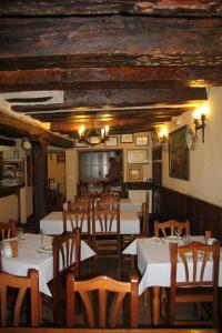 昆卡波萨达汀特兹酒店的用餐室配有白色的桌子和木椅