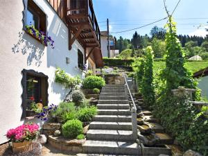 LangenbachQuaint Farmhouse in Langenbach near the Lake的一座花园,旁边是一座带楼梯和鲜花的花园