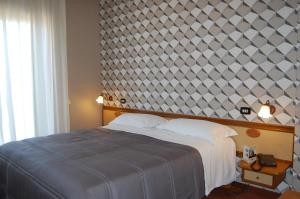 Calvizzano多纳托餐厅酒店的一间卧室设有一张大床和大墙