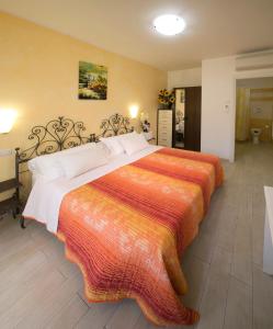 努马纳Giglio Del Conero的一间卧室配有一张大床和色彩缤纷的毯子