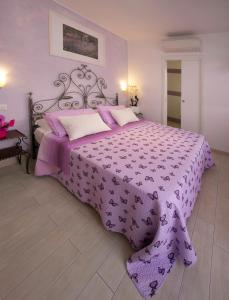 努马纳Giglio Del Conero的一间卧室配有一张带紫色床罩的床