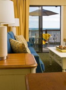 普罗温斯敦萨福赛德套房酒店的带沙发和桌子的客厅以及阳台。