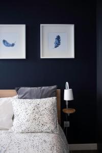 圣克鲁斯-德特内里费Home2Book Stunning&Design Apartment Santa Cruz的卧室配有一张床,墙上挂有两张照片