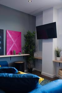 圣克鲁斯-德特内里费Home2Book Stunning&Design Apartment Santa Cruz的客厅配有蓝色的沙发和平面电视。