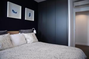 圣克鲁斯-德特内里费Home2Book Stunning&Design Apartment Santa Cruz的卧室设有黑色的墙壁和一张带白色枕头的床。