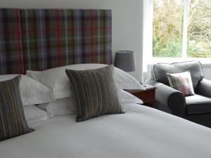 巴克斯顿Grendon Bed & Breakfast的卧室配有白色床、椅子和窗户
