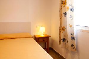 贝纳尔马德纳瑟拉玛尔酒店的一间卧室配有一张床和一张桌子上的台灯