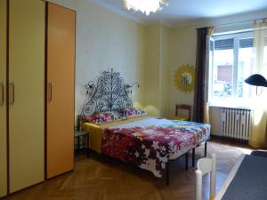 都灵Casa Clemente in Cit Turin的一间卧室配有一张带花卉床罩的床和窗户。