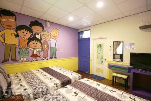 绿岛绿岛禾风旅栈的卧室的墙上挂有卡通画