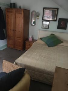 塞尔基石旅馆的一间卧室配有一张床和一个木制橱柜