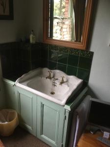 塞尔基石旅馆的浴室设有白色水槽和镜子