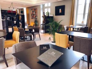 拉蒙维尔圣阿尼Domaine de Montjoie - Toulouse - BW Premier Collection的一间带桌椅和一本书的餐桌
