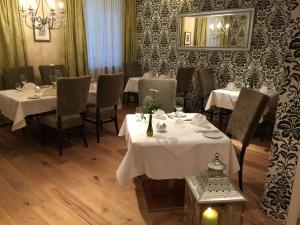 格伦察-维伦ZUM ZIEL Hotel & Restaurant Grenzach-Wyhlen bei Basel的餐厅配有白色的桌椅和镜子