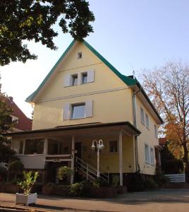 汉诺威Finkenhof - Haus Meersmannufer的一座黄色的大建筑,有绿色的屋顶