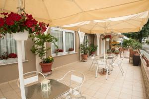 奥林匹亚基·阿克蒂Atira Apart Hotel的一个带桌椅和遮阳伞的庭院
