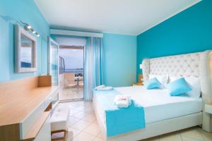 克里斯阿穆迪亚塔索斯阳光酒店的一间卧室配有一张蓝色墙壁的床