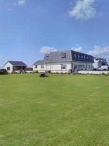 西班牙角Lahiff's Bay View Guest House的一座大型白色建筑,拥有一片大片草地