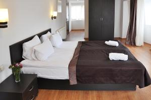 第比利斯科尔诺酒店的一间卧室配有一张大床和两条毛巾