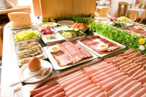 UnterlammPension Drei-Mäderl-Haus的餐桌上的自助食物,包括肉类和蔬菜