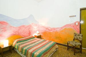 门多萨卡萨普韦布洛旅舍的一间卧室配有一张壁画床