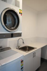 珀斯Just triggin的厨房配有水槽和洗衣机
