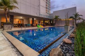 泗水The Square Surabaya Hotel的一座蓝色瓷砖的游泳池