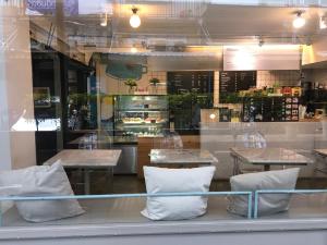 曼谷P24卡塞特酒店的餐厅设有桌子和窗户上的白色枕头