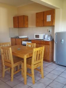 EmhubeniWhite Mountain Resort的厨房配有木桌、椅子和冰箱。