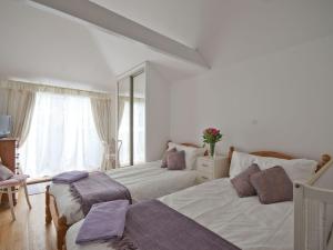 卡兰斯拓克Rosemaddon的一间卧室设有两张床和大窗户