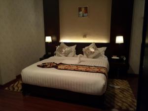 亚的斯亚贝巴夏尔拉亚的斯酒店的卧室配有一张带白色床单和枕头的大床。