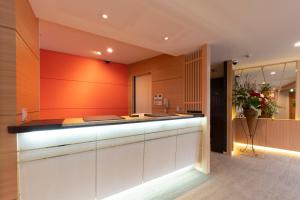京都京都清水露台酒店的厨房设有橙色墙壁和柜台