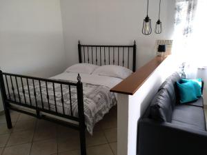罗维尼安尼卡公寓酒店的一间卧室配有一张床和一张沙发