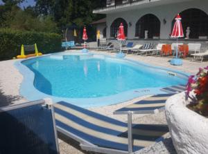 阿尔梅诺Hotel Madonna di Luciago的一个带椅子和遮阳伞的大型游泳池