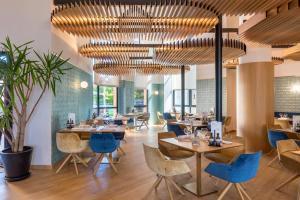 卡塞雷斯巴瑟罗卡塞雷斯五世世纪酒店的餐厅设有木制天花板和蓝色的桌椅