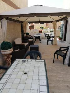阿尔代亚和平之鹭住宿加早餐旅馆的庭院配有桌椅和遮阳伞。