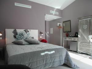 丰维耶L' Oustau Blanc B&B的一间卧室配有一张带镜子和梳妆台的床
