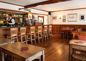 伦维尔Renvyle House Hotel & Resort的餐厅内的酒吧配有木桌和椅子