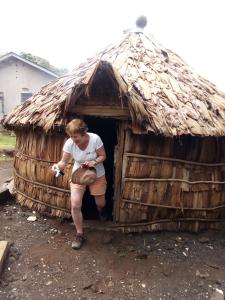 MachameMachame Nkweshoo Cultural Tourism的女人坐在茅草小屋里