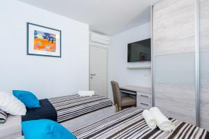 杜布罗夫尼克Apartments Lazarin的一间卧室配有两张床和一张书桌