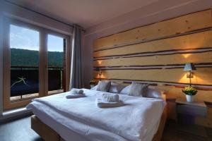 派克波特斯耐兹库Hotel Obzor的卧室设有一张大白色的床和大窗户