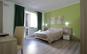 莱切Nidi di Feo的一间卧室配有一张带绿色墙壁的床和一把椅子