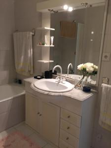 波瓦-迪瓦尔津Casa na Praia的浴室配有盥洗盆、镜子和浴缸